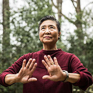 Senior woman doing Tai Chi outdoors.